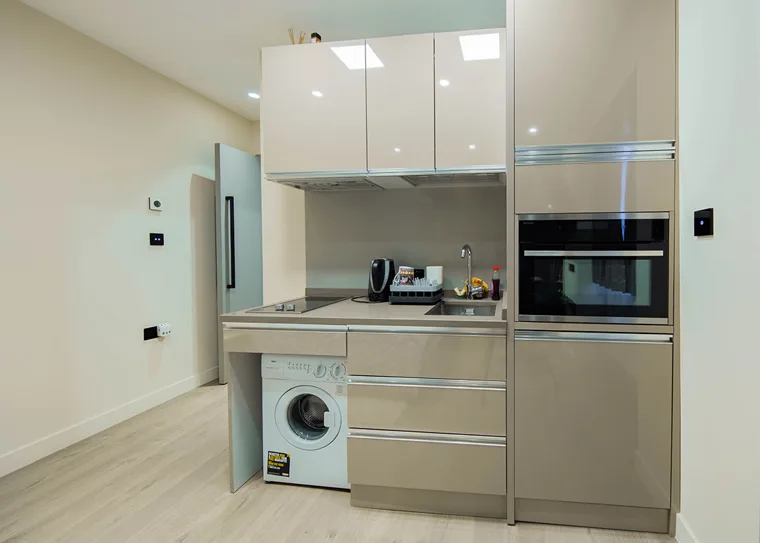 Kitchenette with washing machine, fridge freezer and oven