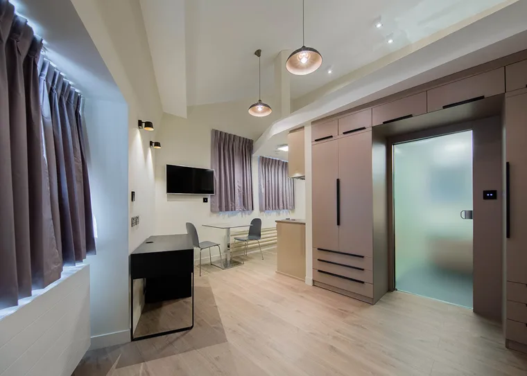 Open-plan studio with a desk and fitted storage